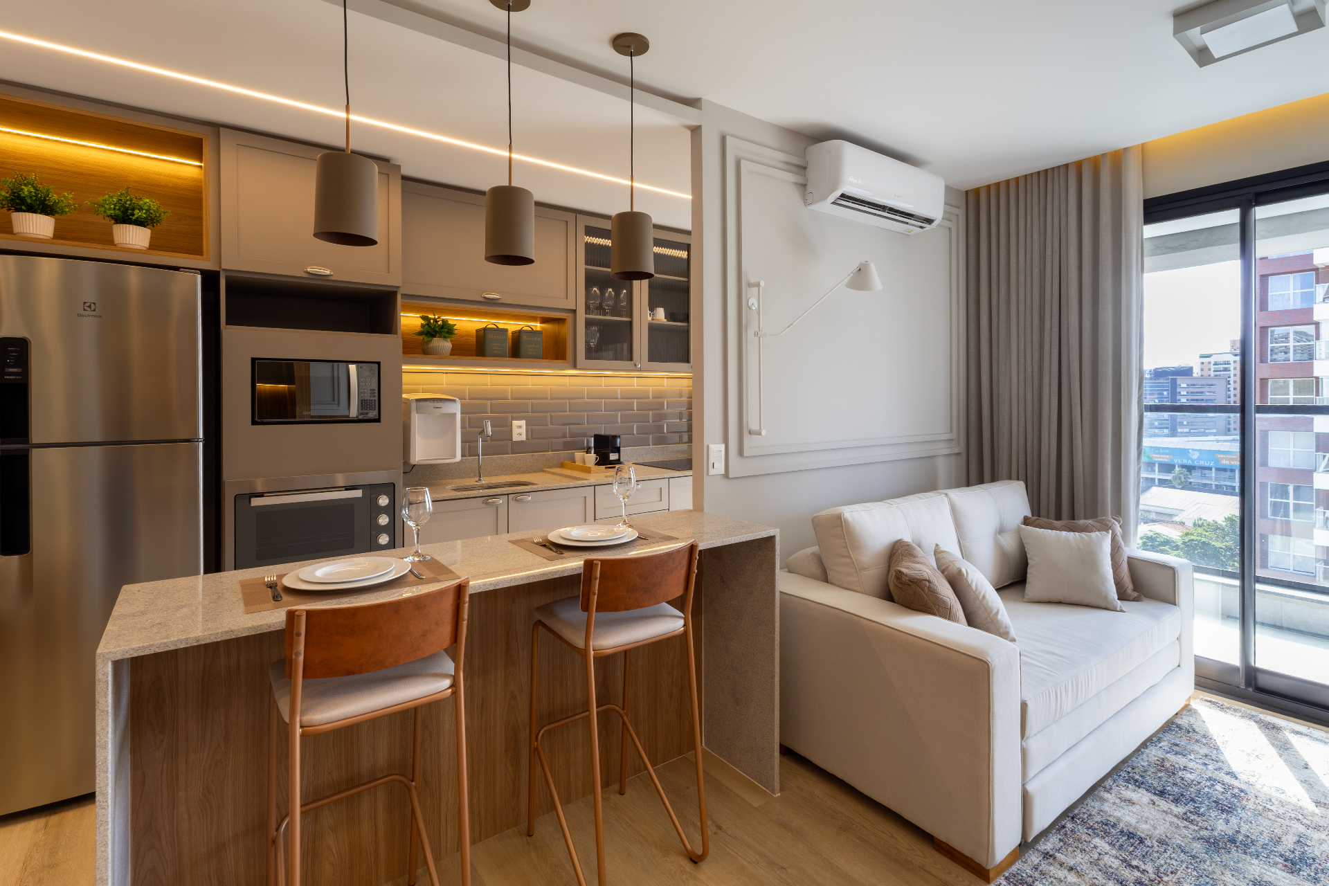 Interior de apartamento HostOne mobiliado no Cambuí, Campinas — luz natural e madeira clara